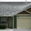 Hail accumulates on the roofs of houses