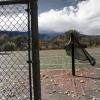 Wind blowing across disused tennis courts behind the mansions